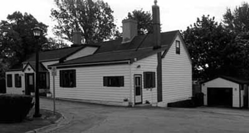 Corner view of the Commanding Officer's Residence, showing its low residential scale and massing, 1991.; Parks Canada Agency / Agence Parcs Canada, 1991.