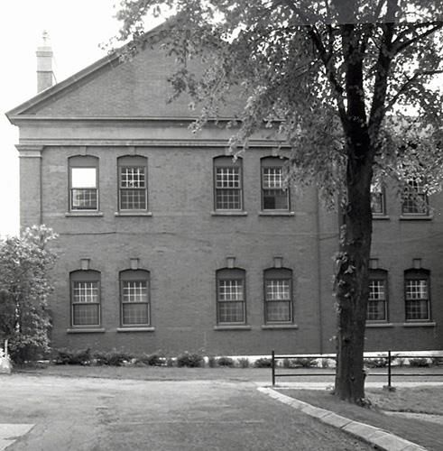 Façade of the Officers' Married Quarters, showing the segmentally arched windows grouped in pairs with ornamental keystones, 1991.; Parks Canada Agency / Agence Parcs Canada, I. Doull, 1991.