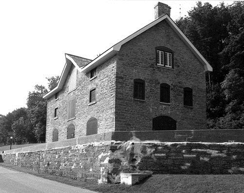 Corner view of the Commissariat Building, showing the fenestration pattern on the north elevation, which illustrates its original administrative and residential functions, 1989.; Parks Canada Agency / Agence Parcs Canada, Couture, 1989.