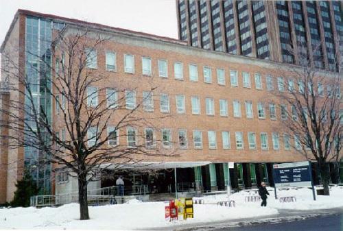 Façade of the Administration Building, showing the broad expanses of exterior brick veneer and the long horizontal bands of windows, 1998.; Parks Canada Agency / Agence Parcs Canada, J. Mattie, 1998.
