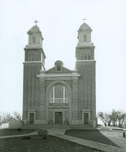 Front elevation of the Cathedral of Our Lady of the Assumption, part of the Gravelbourg Ecclesiastical Buildings National Historic Site of Canada, showing its twin towers crowned by cupolas.; Parks Canada Agency / Agence Parcs Canada