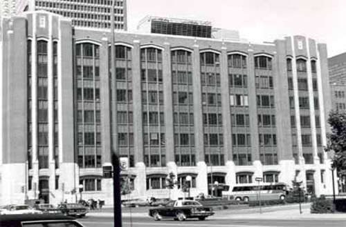 View of the façade of the Federal Building, showing the use of metal spandrels between each of the wide windows, which visually unites the space between the piers into a series of elongated panels, 1978.; Parks Canada Agency / Agence Parcs Canada, 1978.