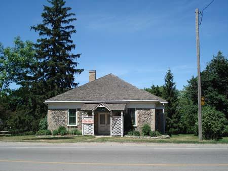 Of note are the hip roof, cobblestone construction and small entrance portico.; Kendra Green, 2007.