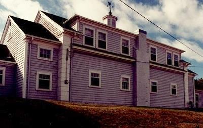 Rear view of the Coach House, showing its two-storey, symmetrical massing composed of a prominent centre block with one-storey side wings, 1988.; Department of National Defence / Ministère de la Défense nationale, 1988.