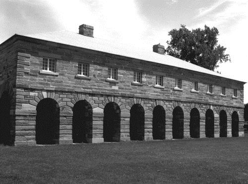 View of the front façade of the Guardhouse, showing the architectural composition of the building, which consists of a rectangular plan, arcaded portico and hipped roof.; Parks Canada Agency / Agence Parcs Canada.