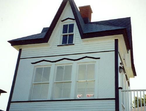 Detail view of Cabin 1, showing the tall dormers whose ridges meet in the centre where the chimney rises.; Parks Canada Agency / Agence Parcs Canada.