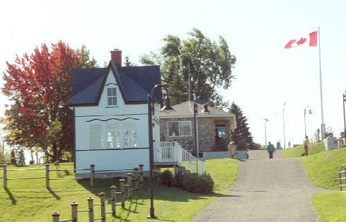 Side elevation of Cabin 1, showing the walls of the building, clad in white wood siding.; Parks Canada Agency / Agence Parcs Canada.