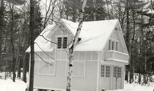 View of the façade of the Garage and Servant's Quarters, showing the wood construction clad in shiplap siding and wood planks applied in a grid pattern at the second storey.; Parks Canada Agency / Agence Parcs Canada.