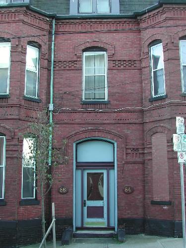 This photograph shows the central bay of the residence, as well as the brickwork, segmented arch openings and the cornice with small dentils, 2005; City of Saint John