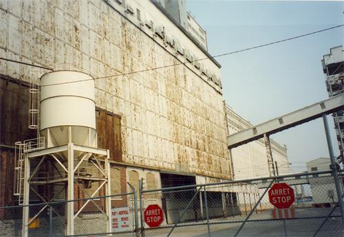 View of the exterior of Elevator 5 B, showing its overall scale, design and materials, which enhance the industrial and port character in the western sector of the Old Port, 1995.; Parks Canada Agency / Agence Parcs Canada, J. Hallé, 1995.