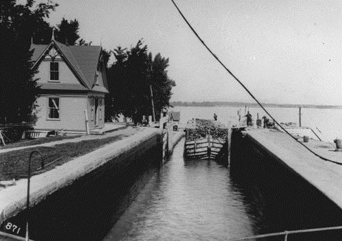 Exterior view of Cabin 3, showing the architectural lines of the Queen Anne Revival inspired wooden cabin, such as the complex profile of the steep roof, 1911.; Library and Archives Canada / Biblothèque et archives Canada, PA-85627, 1911.