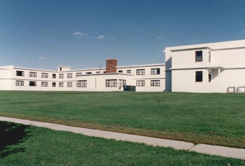 View of the rear façade of Building B-39, showing the wrap-around continuity of the belt courses, 1993.; Parks Canada Agency / Agence Parcs Canada, 1993.