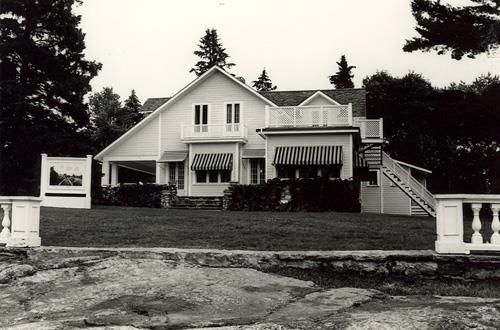 View of the entrance of the Main House, showing the one-and-a-half storey, asymmetrical massing with a gable roof and the window arrangement and treatment, 1984.; Parks Canada Agency / Agence Parcs Canada, M. Trépanier, 1984.