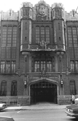 Front view of the Cathcart Armoury, showing the elements of the Tudor Gothic style such as the low ogee arch of the windows and main entrance, 1983.; Canadian Cultural Programmes / Programmes culturels canadiens, 1983.