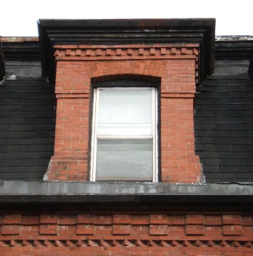 This image provides a view of the central segmented arch dormer ornamented by dentils above the cornice, 2005
 ; City of Saint John