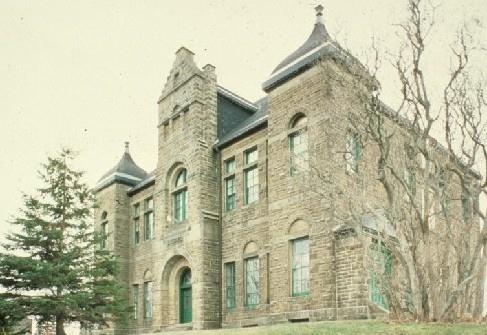 Corner view of Monument-Lefebvre National Historic Site of Canada, showing the imposing rusticated olive sandstone.; Parks Canada Agency / Agence Parcs Canada.