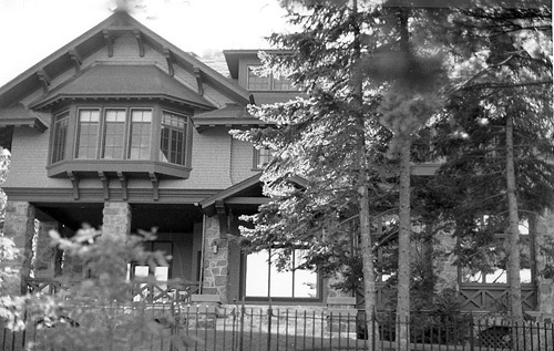 Façade of the Main House, showing the use of varied materials, including rough stone, imitation stone walls, wood shingles and half timbering, 1984.; Parks Canada Agency / Agence Parcs Canada, Robert Hunter, 1984.