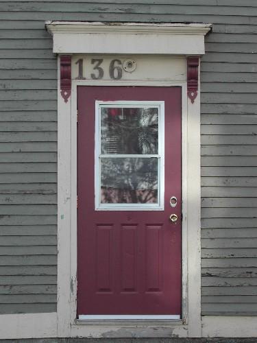 This photograph shows the entrance to the building with a bracketed entablature, 2005; City of Saint John