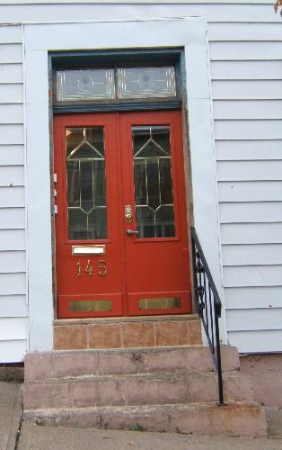 This image provides a view of the entry with the two paned transom window above paired doors, 2005; City of Saint John