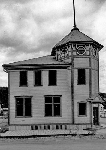 View of the front entrance of the Post Office, showing the octagonal tower, which gives the building a sense of stability, defines the entry and provides an important focal point in the town, 1987.; Parks Canada Agency / Agence Parcs Canada, 1987.