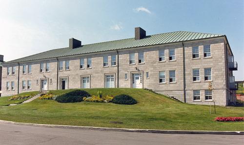 General view of Building 17, showing the solid massing with hipped, copper-clad roof, 1980.; Department of National Defence / Ministère de la Défense nationale, 1980.