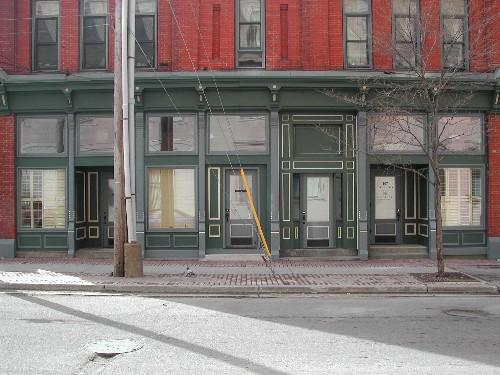 This photograph shows the storefront of the building and illustrates the recessed entranceways and cast iron pilasters, 2005; City of Saint John