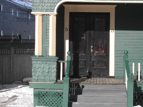 This photograph shows the entrance and the shingled bases of the square pilasters, 2005; City of Saint John