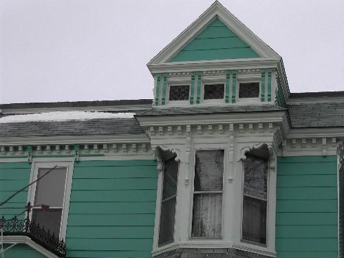 This photograph shows the upper portion of the ornate bay window topped by a gable dormer, 2005; City of Saint John