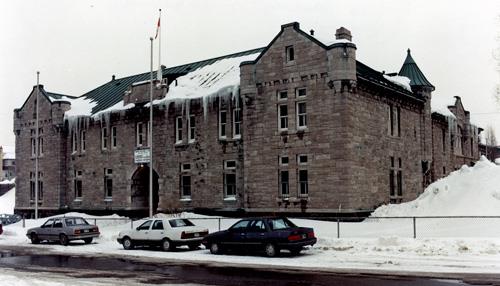 General view of the Armoury, showing the well-scaled façades executed in rough-faced limestone with carved and smooth detailing, 1990.; Department of National Defence / Ministère de la Défense nationale, 1990.