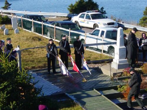 Photo of a Remembrance Day ceremony at the war memorial, First Anglican Cemetery and War Memorial Site, Arnold's Cove, NL, circa 2006; Town of Arnold's Cove, 2008