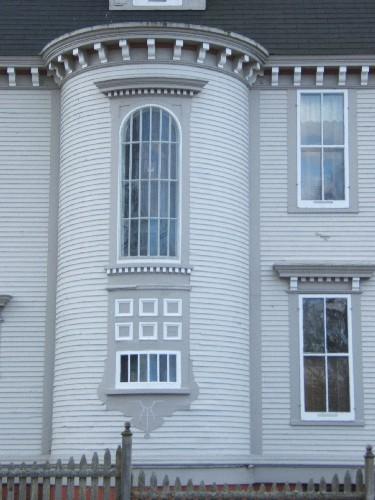This photograph shows the highly ornate bow window characterized by a large roman arched window and decorative panels below, 2006; City of Saint John