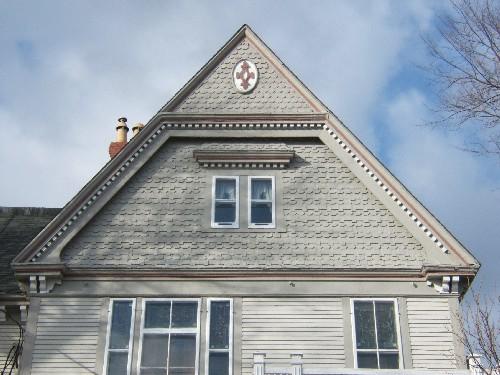 This photograph shows the ornate gable with fancy shingling and insignia near the peak, 2006; City of Saint John