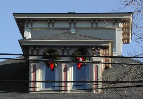 This image provides a view of the belvedere and the central dormer with a hipped roof and double Roman arched windows above a wood cornice supported by a series of paired, scrolled brackets, 2006
; City of Saint John