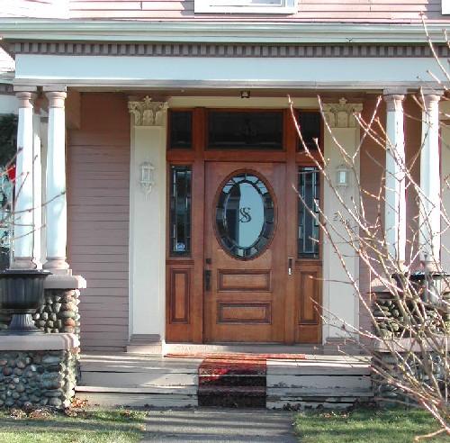 This image provides a view of the entrance flanked by Corinthian pilasters and consisting of a stained glass transom window, sidelights and a wooden door with a rounded, glass panel, 2006
; City of Saint John