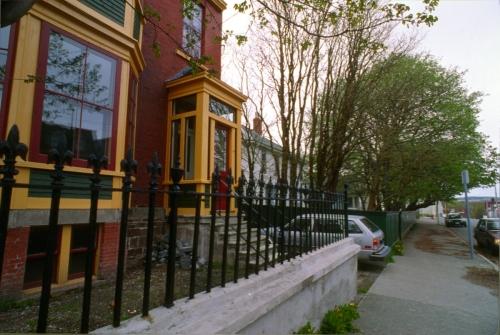 Detailed view of the wrought iron fence and a close view of the main window and porch.  Photo taken after restoration, post 1992.; HFNL 2007