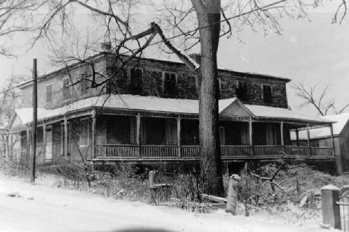 General view of the Macdonell House, showing its rubble stone construction with wood detailing, 1969.; Parks Canada Agency, Agence Parcs Canada, 1969.