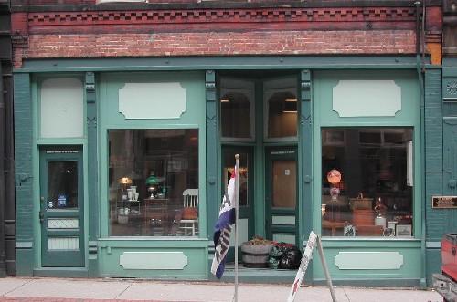 This photograph shows the storefront with brick and cast iron pilasters and deeply recessed entrance, 2005; City of Saint John