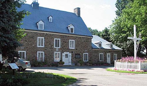 Exterior view of Maison Saint-Gabriel, showing the east lean-to and the wooden cross, 2005.; Parks Canada Agency / Agence Parcs Canada, N. Clerk, 2005.