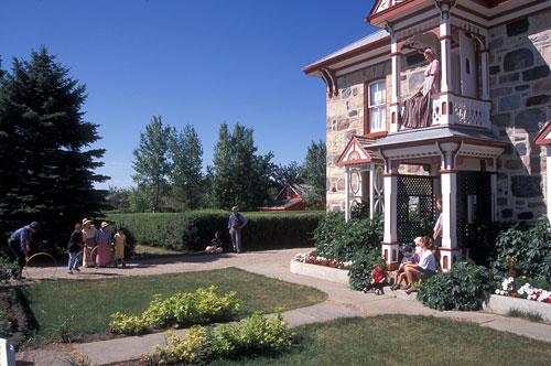 Corner view showing the two-storey projecting gabled porch and balcony on the main elevation.; Parks Canada Agency / Agence Parcs Canada