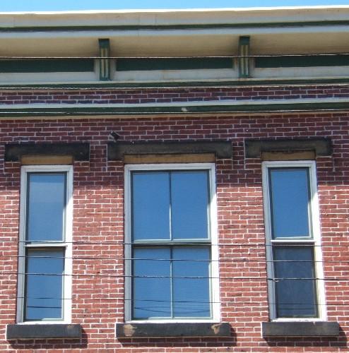 This photograph shows the roof-line cornice and the set of three windows, 2005; City of Saint John