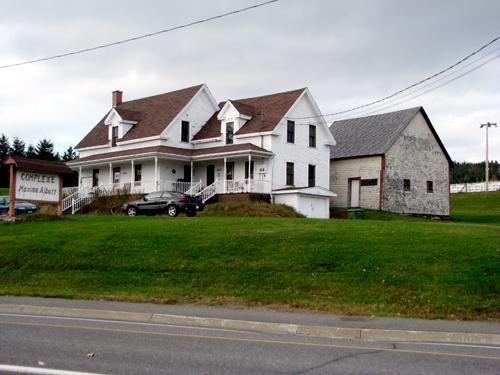 The building constructed in 1895 is in the foreground. The building constructed in 1865 is in the background. There is also a sign that says "Complexe Maxime Albert".; Madawaska Planning Commission