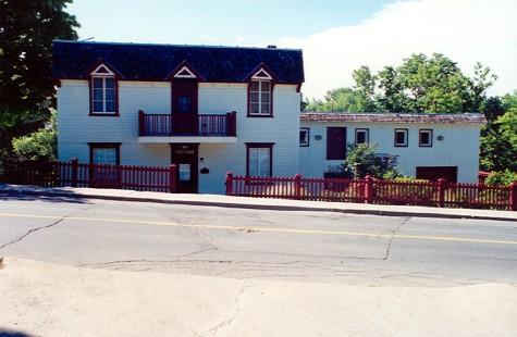View of the miller's house at Légaré Mill, showing its vernacular early 20th century details such as carved window frames and roof brackets, 1999.; Parks Canada Agency / Agence Parcs Canada, 1999.