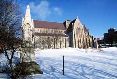 View of the side of St. John the Baptist Anglican Cathedral, showing its rugged construction of Irish limestone and local granite, 1994.; Parks Canada Agency | Agence Parcs Canada, J. Butterill, 1994.