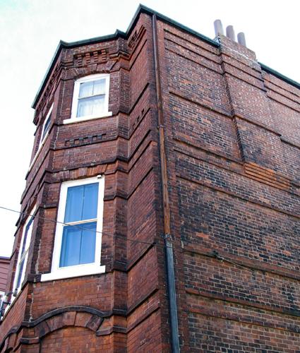 This image shows the brick masonry detail including string courses, corbelling, flat and segmental arches, 2007; City of Saint John