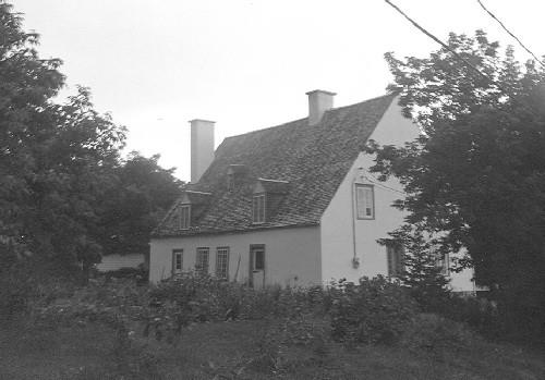 Corner view of the Pagé - Rinfret / Beaudry House, showing its steeply pitched gable roof, 1989.; Parks Canada Agency / Agence Parcs Canada, 1989.
