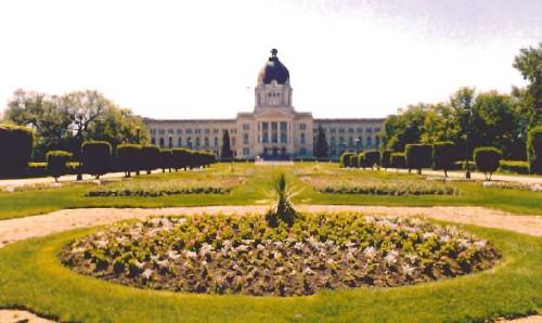 General view of the Legislative Building, showing its lawns, flower beds, shrubs and trees encircled and crossed by walkways and driveways, 1998.; Parks Canada Agency / Agence Parcs Canada, 1998.