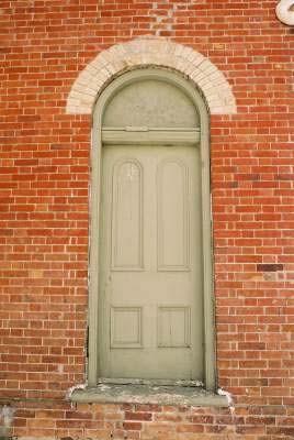 View of the exterior of Former Atha School House, showing the round-headed upper panelling of the door, 2005.; Department of Public Works and Government Services / Ministère des Travaux publics et services gouvernementaux, Alice Da Silva, 2005.