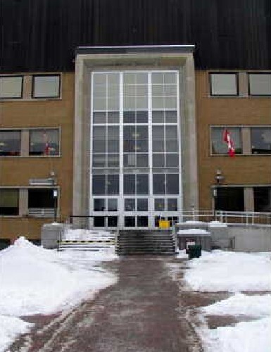 Detail view of the Statistics Canada Building, showing the verticality of its main entrances, with their heavy stone frames and generous glazing extending three storeys high, 2005.; Parks Canada Agency / Agence Parcs Canada, Geneviève Charrois, 2005.