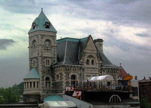 General view of the Former Galt Post Office, showing the imposing side tower with a clock and pyramidal roof.; Parks Canada | Parcs Canada, 1989