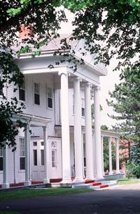Detail of Government House, showing its double-height columned portico over the central entry, 1995.; Parks Canada Agency / Agence Parcs Canada, J. Butterhill, 1995.